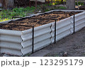 Permaculture raised warm bed made of slate with branches at the base in the garden 123295179
