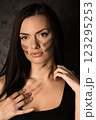 Beautiful woman applying camouflage military makeup to her body 123295253