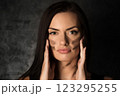 Beautiful woman applying camouflage military makeup 123295255