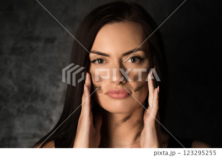 Beautiful woman applying camouflage military makeup Beautiful woman applying camouflage military makeup 123295255