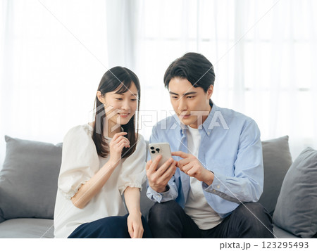 リビングルームでスマホを見るカップル 123295493