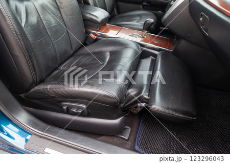 Close-up on front passenger seat with black leather trim and ottoman for legs rest upholstery in the interior of an Japanese car in gray after dry cleaning. Auto service industry. 123296043