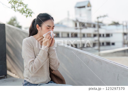 Young woman struggling with allergies in polluted environment, emphasizing health concerns. 123297370