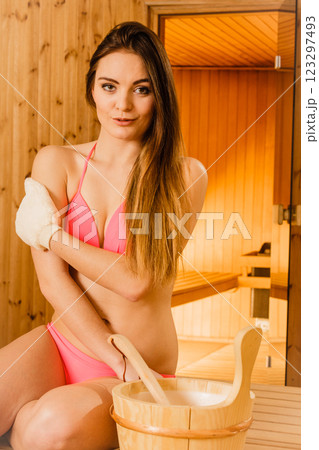 Woman in sauna with exfoliating glove. Skincare. 123297493