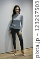 Positive woman 51 years old with evening make-up in a grey sweater and jeans in pink high-heeled shoes posing and looking at the camera 123297503