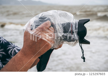 digital camera in waterproof case and a protective plastic bag against rain splashes in male hands of photographer digital camera in waterproof case and a protective plastic bag against rain splashes in male hands of photographer 123297603