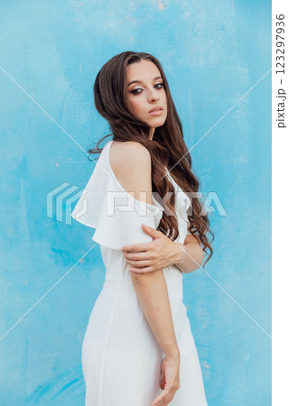 Beautiful Brunette Woman in White Suit on Blue Background Beautiful Brunette Woman in White Suit on Blue Background 123297936