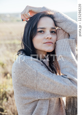 Beautiful brunette woman in sweater in rural area Beautiful brunette woman in sweater in rural area 123298220