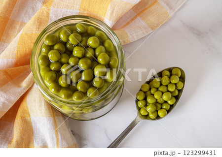 Full jar of canned green peas over marble tabletop. 123299431