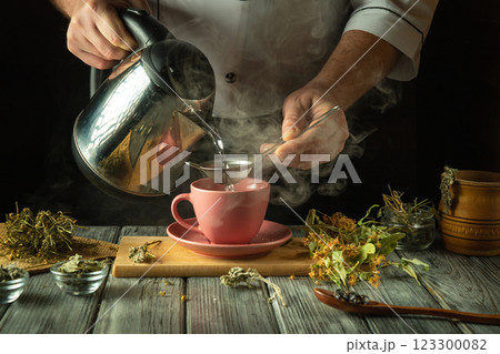 Steam rises as a skilled hand pours hot water over carefully selected herbs into a pink cup. The kitchen is filled with the earthy aroma of nature's remedies, creating a cozy atmosphere Steam rises as a skilled hand pours hot water over carefully selected herbs into a pink cup. The kitchen is filled with the earthy aroma of nature's remedies, creating a cozy atmosphere 123300082