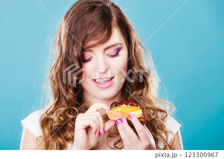 Cute girl holds fruit cake in hand on blue Cute girl holds fruit cake in hand on blue 123300967