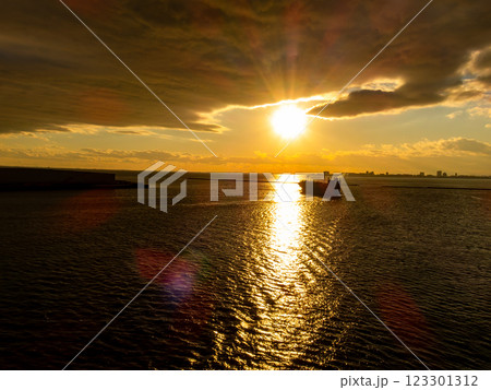 東京湾の美しい夕陽の中、出港していく貨物船 123301312