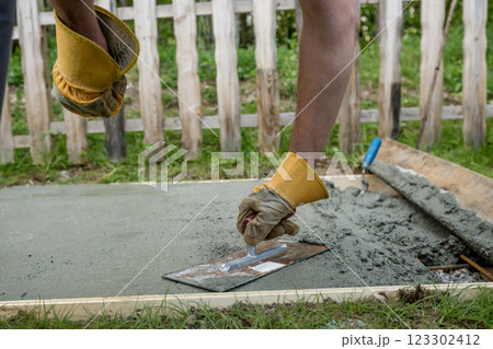 Closeup view of a workman leveling a concrete surface Closeup view of a workman leveling a concrete surface 123302412