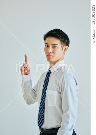 人差し指を立てるワイシャツ姿の若い男性 123302825