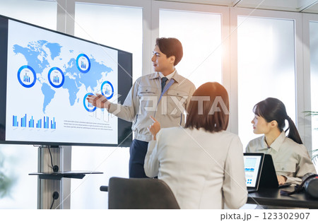 大画面モニターの前でミーティングする作業員のグループ 123302907