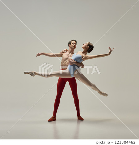 Ballet partners in motion extending arm, posing gracefully and gaze to each other expressing trust against white studio background. Ballet partners in motion extending arm, posing gracefully and gaze to each other expressing trust against white studio background. 123304462