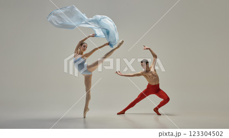 Young artistic ballet dancers performing dynamic pose with fluid and expressive movement against minimal background. Concept of grace, beauty 123304502