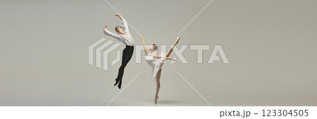 Banner. Ballet dancer spinning in controlled turn, partner gazing with admiration, delicate lines enhancing moment against white studio background. 123304505