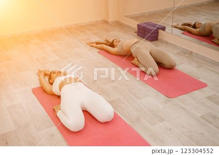 Two beautiful women do yoga, sports in the gym. The concept of grace and beauty of the body. 123304552