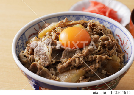 玉子の黄身を乗せた美味しそうな牛丼 123304610