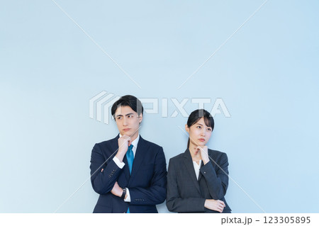 首を傾げて考える男女ビジネスパーソン 首を傾げて考える男女ビジネスパーソン 123305895