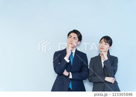 首を傾げて考える男女ビジネスパーソン 123305896