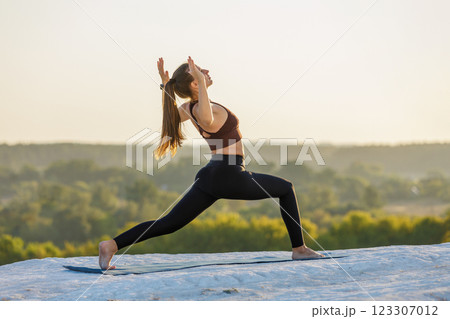 Yoga practice during sunset on a scenic mountain overlook 123307012