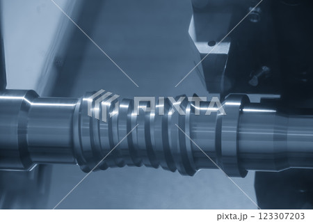 The CNC lathe machine forming cutting the metal screw shaft parts in the light blue scene. The CNC lathe machine forming cutting the metal screw shaft parts in the light blue scene. 123307203