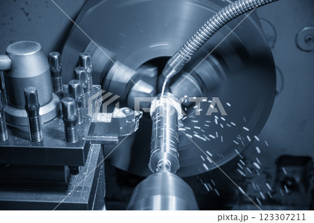 The lathe machine finish cut metal shaft parts with liquid coolant method in the light blue scene. The lathe machine finish cut metal shaft parts with liquid coolant method in the light blue scene. 123307211