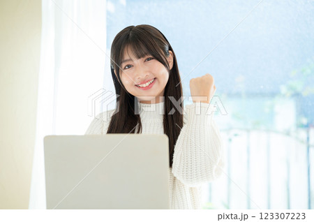 パソコンの前でガッツポーズをする女性 パソコンの前でガッツポーズをする女性 123307223