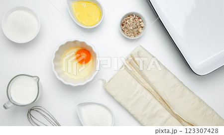 Baking Crinkle Cake, near dish with ingredients, phyllo dough, egg, butter, nuts, milk 123307428