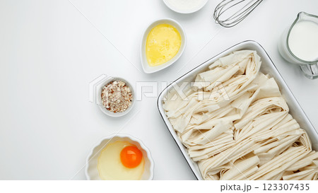Crinkle Cake baking, filo dough in a baking dish near milk, eggs, butter, butter, sugar 123307435