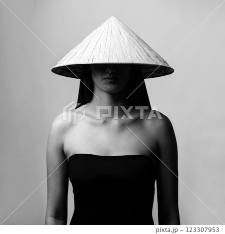 Beautiful woman with Asian cane hat black and white studio portrait 123307953