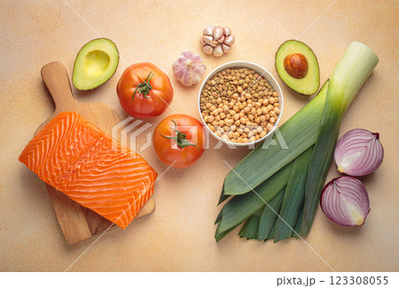 Fresh salmon, vegetables, legumes, leeks and wooden cooking spoon creating healthy meal ingredients cooking layout Fresh salmon, vegetables, legumes, leeks and wooden cooking spoon creating healthy meal ingredients cooking layout 123308055
