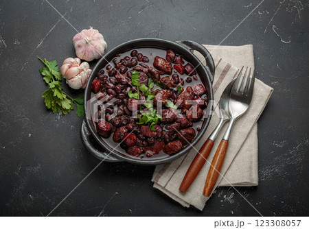 Brazilian feijoada with black beans, sausage and meat in a pot, top view 123308057