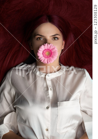 Woman with red hair and flower in her mouth 123308129