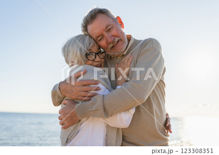 Senior mature couple hugging enjoying outdoor recreation walking on beach. Old husband wife embracing with tenderness love enjoying sweet bonding. Grandmother grandfather together. Family moment love 123308351