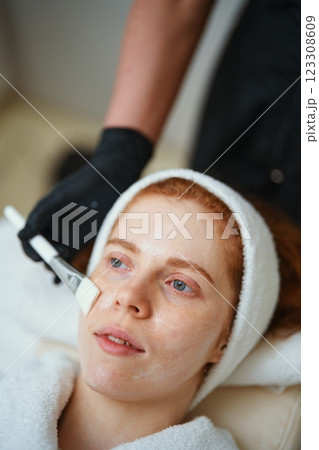 Woman receiving facial treatment at a spa in a relaxing setting 123308609