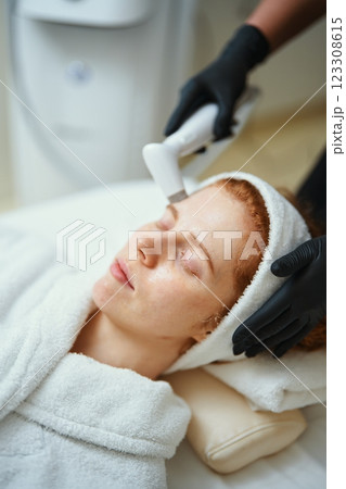 Woman receiving facial treatment in a spa during a wellness session Woman receiving facial treatment in a spa during a wellness session 123308615