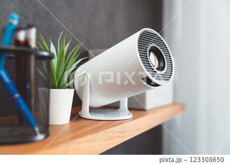 White projector with a lens on shelf 123308650