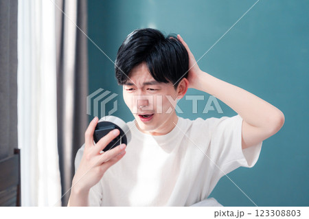 寝坊をして焦る若い男性 123308803