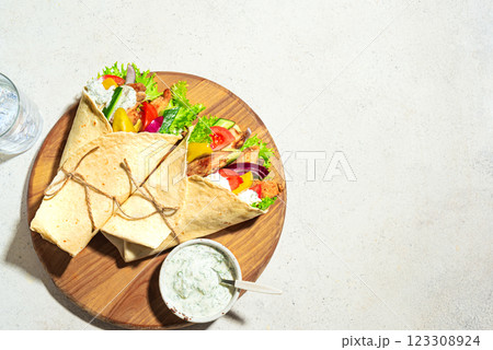 Greek chicken gyros wrap with vegetables and tzatziki sauce 123308924