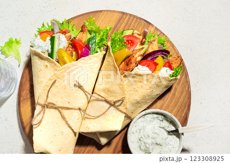 Greek chicken gyros wrap with vegetables and tzatziki sauce Greek chicken gyros wrap with vegetables and tzatziki sauce 123308925