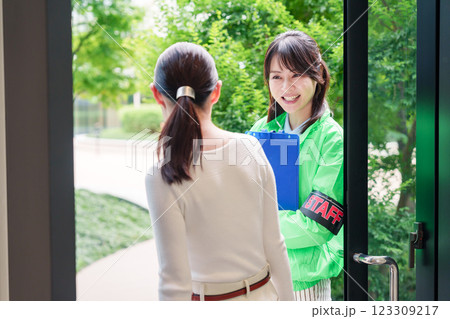 お客様を笑顔で案内するイベントスタッフ 123309217