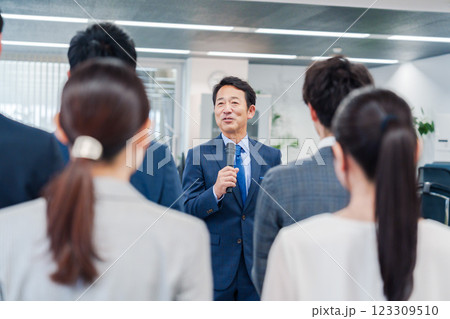 オフィスでの朝礼で挨拶をする管理職の男性 123309510