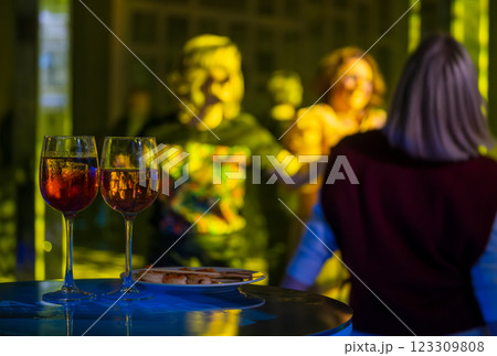 Two glasses of wine on a table at a lively evening party Two glasses of wine on a table at a lively evening party 123309808
