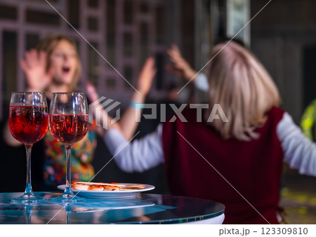 Friends enjoying wine at lively social gathering indoors 123309810