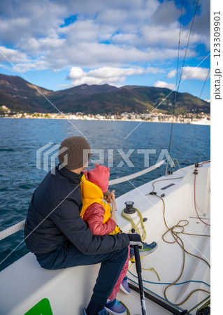 Father instructing daughter on sailing a yacht during training in the Kotor Bay, Montenegro, highlighting family bonding, adventure, and nautical sport. 123309901