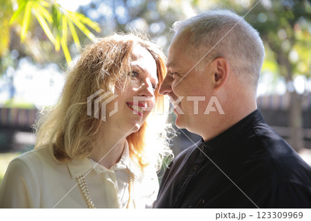 Happy couple smiling and sharing a romantic moment outdoors Happy couple smiling and sharing a romantic moment outdoors 123309969