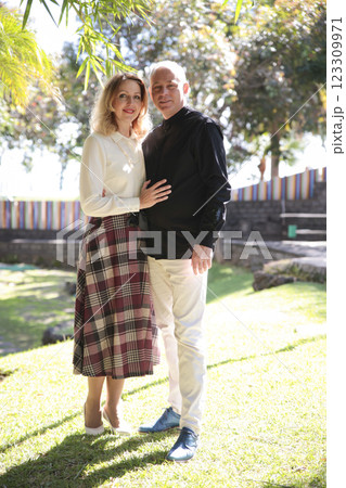 Happy couple smiling and embracing in lush green park in madeira Happy couple smiling and embracing in lush green park in madeira 123309971